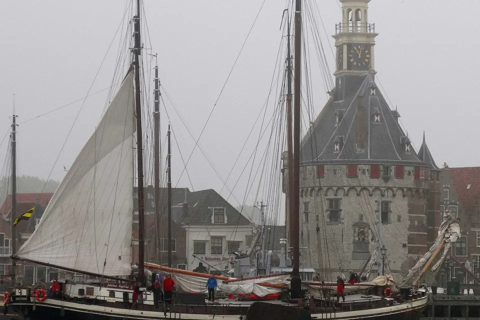 Een oud zeilschip in de haven van Hoorn met de Hoofdtoren erachter